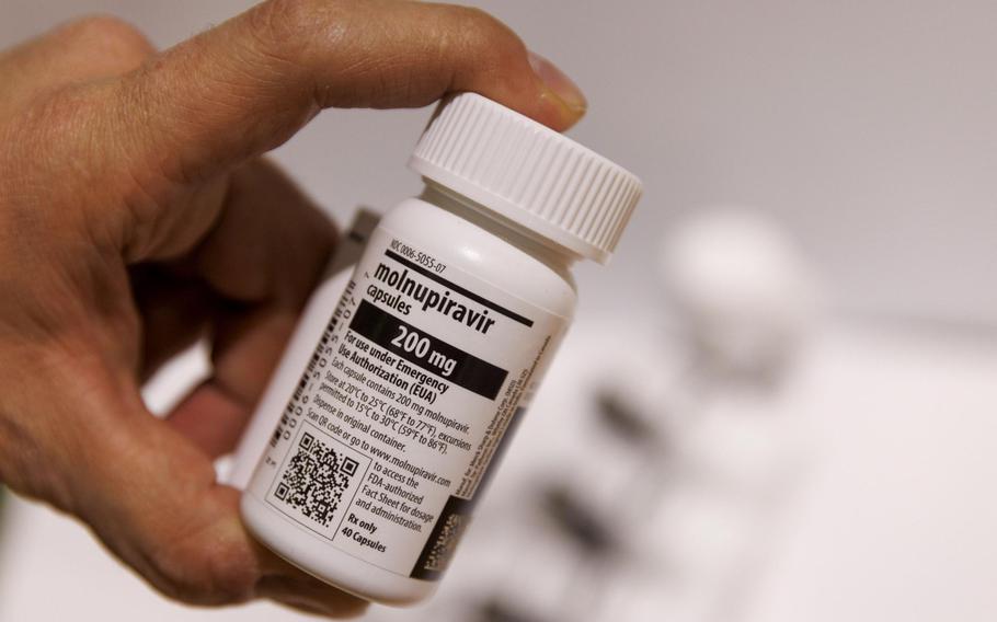 A worker holds a bottle of Molnupiravir antiviral medication in a warehouse in Shoham, Israel, on Jan. 18, 2022. 