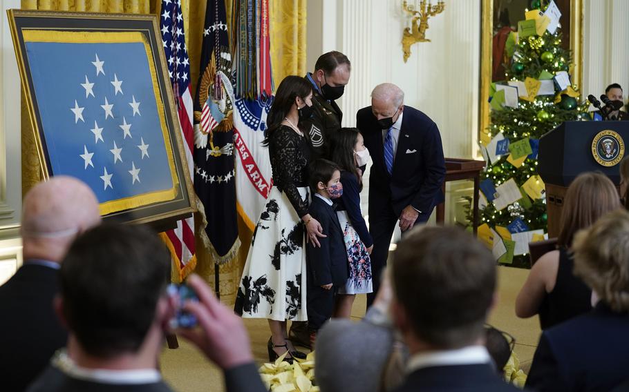 President Joe Biden stands with Army Master Sgt. Earl Plumlee and his family after presenting Plumlee with the Medal of Honor for his actions in Afghanistan on Aug. 28, 2013, during an event in the East Room of the White House, Thursday, Dec. 16, 2021, in Washington. (AP Photo/Evan Vucci)