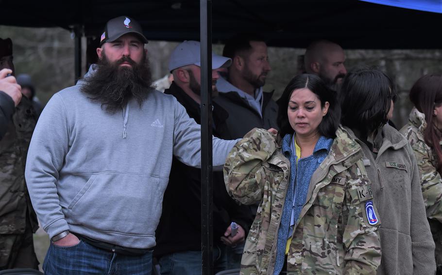 Former platoon member Luke Spencer comforts Cpl. Emmanuel Hernandez’s wife, Jessica, during the drop zone dedication ceremony in honor of her husband at Grafenwoehr, Germany, on April 20, 2023.