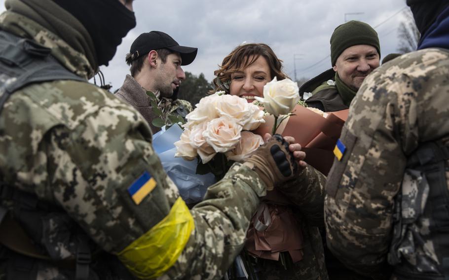 Members of the Territorial Defense Forces give roses to Filimonova. 