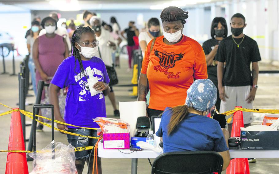 Kristal Thompson, 36, right, and her daughter Skylar Clinch, 8, left, register to get tested for COVID-19 at a testing center inside Joseph Caleb Center in Miami, on July 30, 2021.