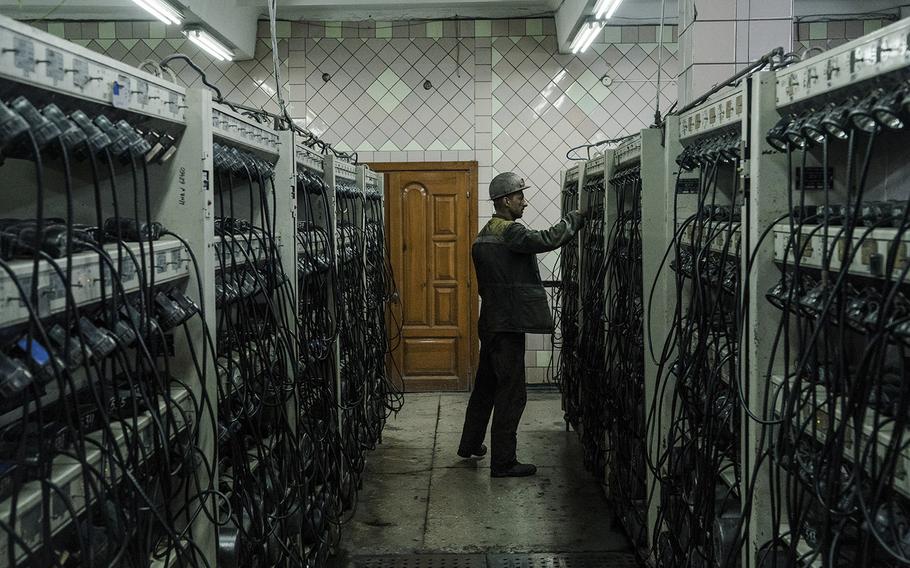 A coal miner stands among rows of equipment during a shift change at a site in Ukraine’s Donbas region. 