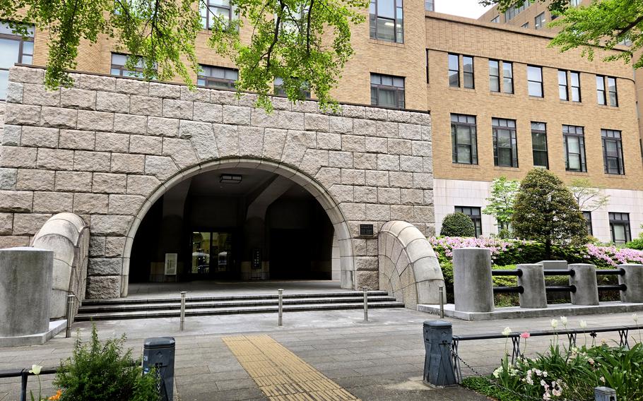 A view of a stone archway entrance to a historic building with a brick and stone exterior. 