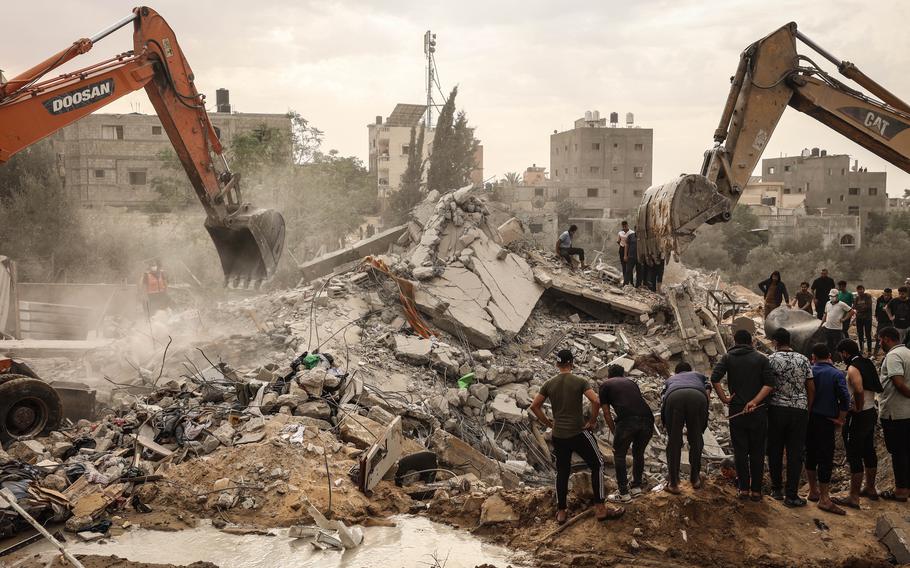 Workers and onlookers at the site of a strike on the Al-Najjar family’s home, east of Khan Younis, in the southern Gaza Strip on Sunday, Nov. 12, 2023.