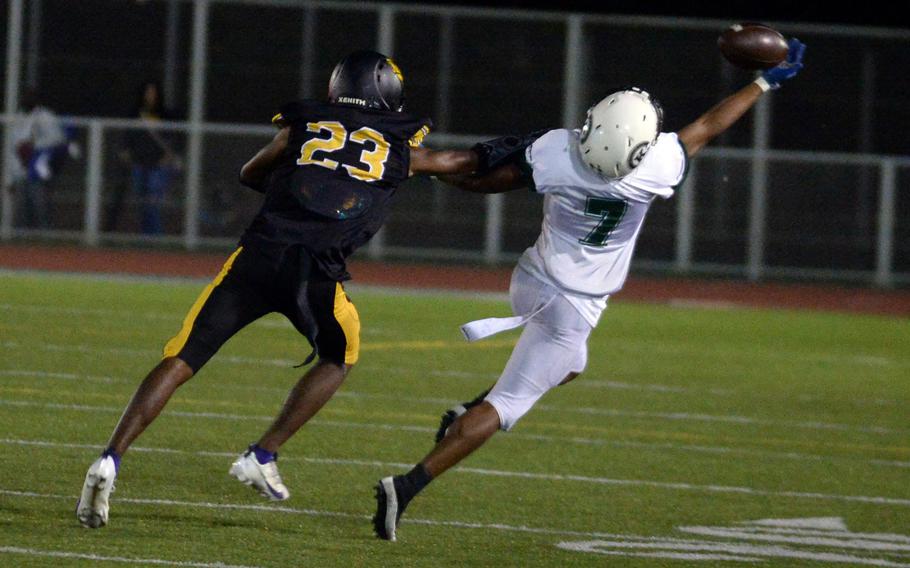 Kubasaki’s Onzei Weaver can’t quite get the handle on the football as Kadena’s Carmelo Ward defends.