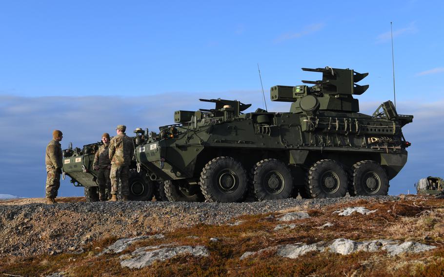 Soldiers stand in front of a short-range missile system.
