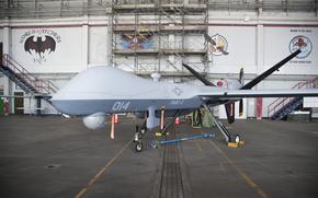 A Marine Corps Reaper unmanned drone is parked in a hangar.