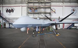 A Marine Corps Reaper unmanned drone is parked in a hangar.
