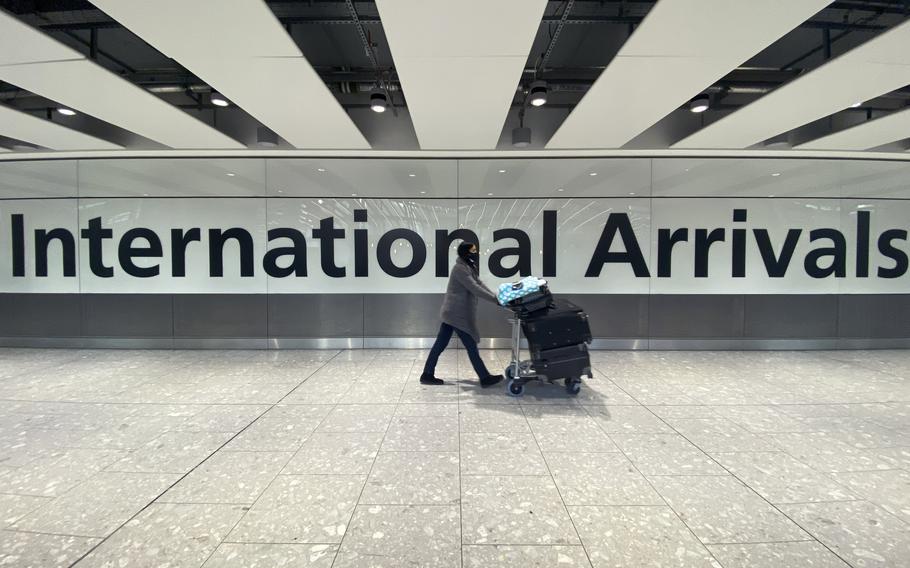 A passenger walks through International Arrivals, at London’s Heathrow Airport, Friday, Nov. 26, 2021. The U.K. announced that it was banning flights from South Africa and five other southern African countries effective at noon on Friday, and that anyone who had recently arrived from those countries would be asked to take a coronavirus test.