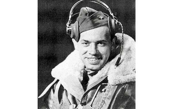 Rauh in his flight jacket with headphones on.