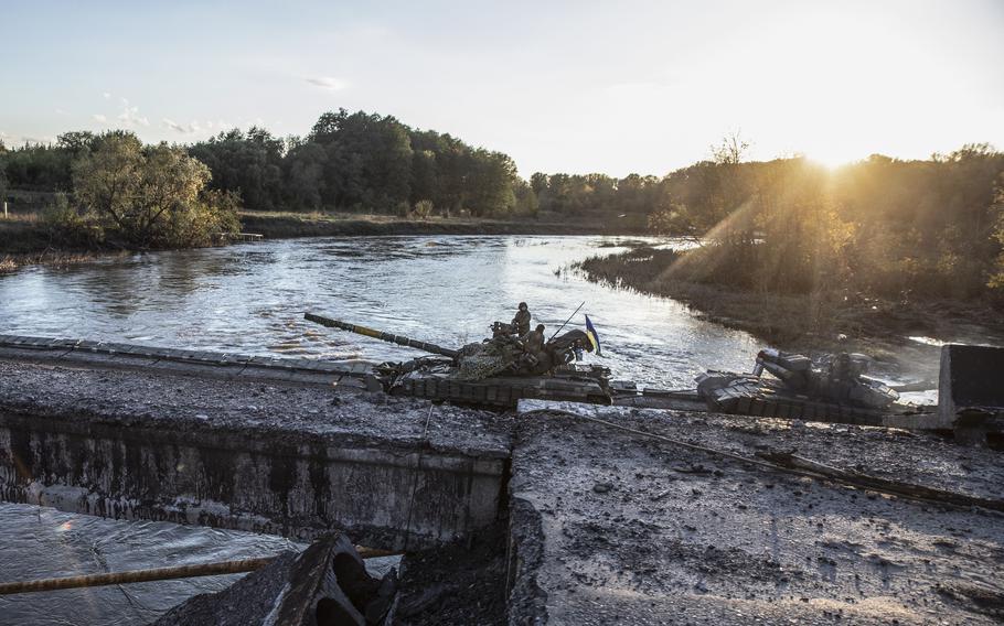 Ukrainian forces on a tank pass a pontoon bridge over the Oskil River in the Kharkiv Oblast on October 3. 