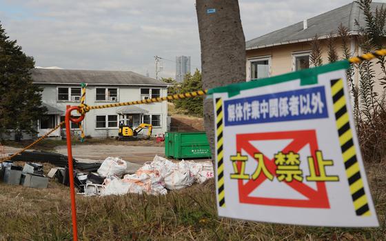 A sign in Japanese, seen here in 2022, warns people to stay out due to demolition at the Negishi Housing Annex in Yokohama, Japan. 