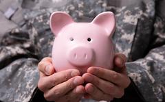 Close-up Of Soldier's Hand Holding Pink Piggy Bank