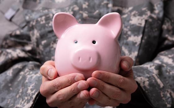 Close-up Of Soldier's Hand Holding Pink Piggy Bank