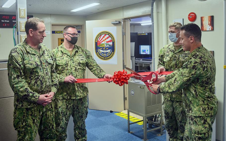 Capt. Steven DeMoss, commander of Naval Surface Group Western Pacific, cuts the ribbon on the new anti-submarine warfare trainer at Yokosuka Naval Base, Japan, Friday, Oct. 15, 2021. 