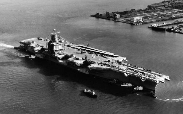A black and white aerial photo of an aircraft carrier.