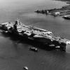A black and white aerial photo of an aircraft carrier.