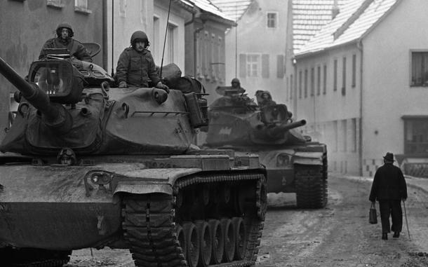 Hed: Going about his business, 1969

Koenigstein, Germany, Feb. 3, 1969: Infantry troops taking part in the Carbide Ice exercise roll through the village of Koenigstein in the Vilseck - Grafenwoehr area, as locals go about their day.

Looking for Stars and Stripes’ coverage of overseas military life through the decades? Subscribe to Stars and Stripes’ historic newspaper archive! We have digitized our 1948-1999 European and Pacific editions, as well as several of our WWII editions and made them available online through https://starsandstripes.newspaperarchive.com/

META TAGS: Europe; West Germany; Reforger; Reforger 1; NATO; exercise; training; Crested Cap; Air Force; Army; USAREUR; servicemember; soldier; dual exercise; training; Carbide Ice; locals; civilians; Cold War; tank