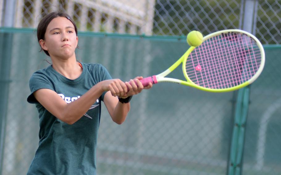 Maya McElroy swings a two-handed backhand.