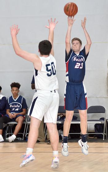 Aviano's Aidan Haas shoots while Black Forest Academy's Joey Ebenroth defends during the final game of pool play at the Division II DODEA European Championships on Thursday at Southside Fitness Center on Ramstein Air Base, Germany. The Saints won 54-42 to clinch the top spot in their pool.