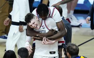 UConn center Youssouf Singare, rear, hugs orward Alex Karaban after the NCAA college basketball game against Alabama at the Final Four, Saturday, April 6, 2024, in Glendale, Ariz.