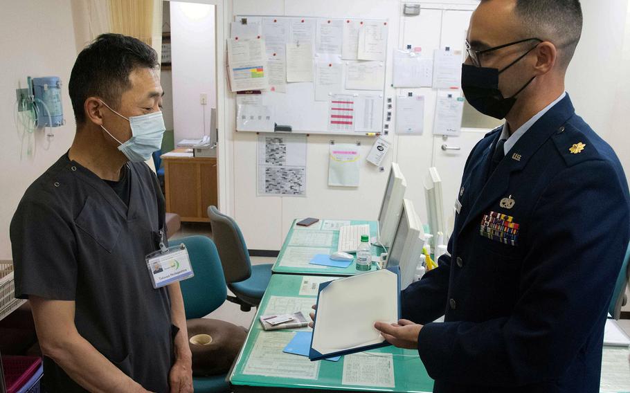 Air Force Maj. Stephan Rose, commander of the 35th Maintenance Squadron at Misawa Air Base, Japan, presents a letter of appreciation to Dr. Tatsuya Nodagahira during a visit to Hachinohe City Hospital on Sept. 16, 2022. Nodagahira and his trauma team saved an airman's life after a major vehicle accident.
