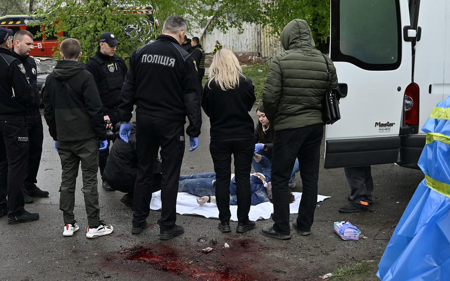 Ukrainian police officers stand by a body after a Russian strike on the historic city of Chernigiv in northern Ukraine on Wednesday, April 17, 2024, killed 17 people and wounded dozens more as Kyiv pleaded for allies to bolster its over-stretched air defense systems.