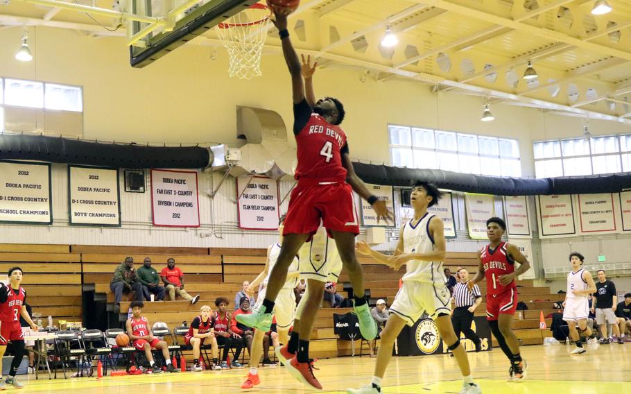 Kinnick’s Kennedy Hamilton skies for the ball against St. Mary’s. The Red Devils edged the Titans 64-62, dethroning the defending champions.