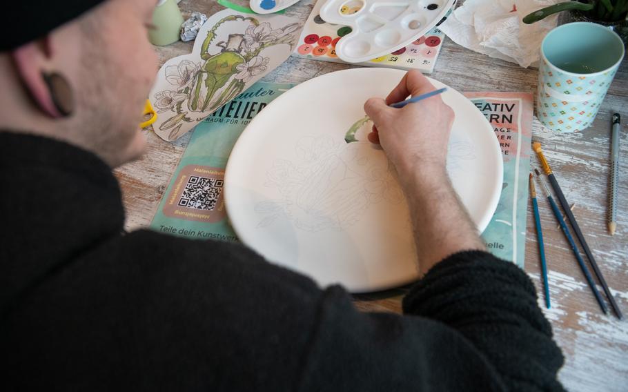 A man paints a plate at Lauter Atelier in Kaiserslautern, Feb. 27, 2024. 