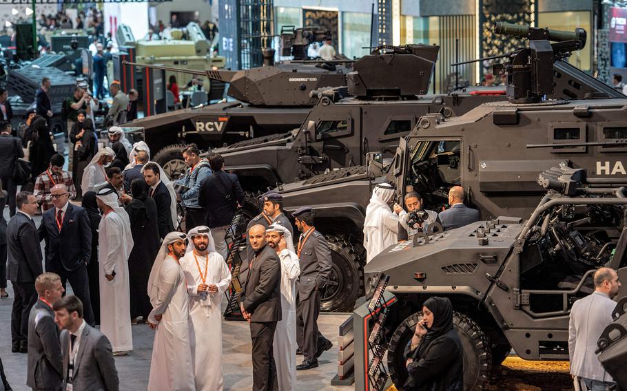 Visitors stand near armoured military vehicles at the EDGE pavilion during the International Defence Exhibtion at the Abu Dhabi International Exhibition Centre on Feb. 20, 2023. (Ryan Lim/AFP/Getty Images/TNS)