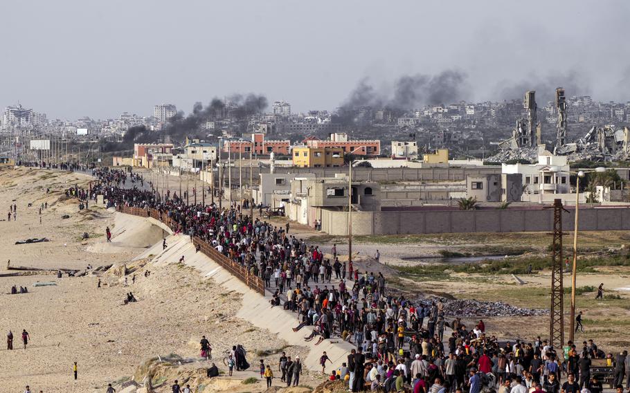 Palestinians Wait for aid trucks to cross in central Gaza Strip on Sunday, May 19, 2024. 