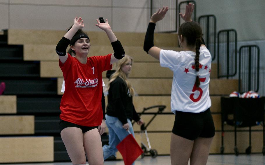 White Team libero M.J. Davis of Ramstein high-fives teammate Emma Boyle of Vilseck during a DODEA-Europe all-star volleyball match on Nov. 4, 2023, at Ramstein High School on Ramstein Air Base, Germany.
