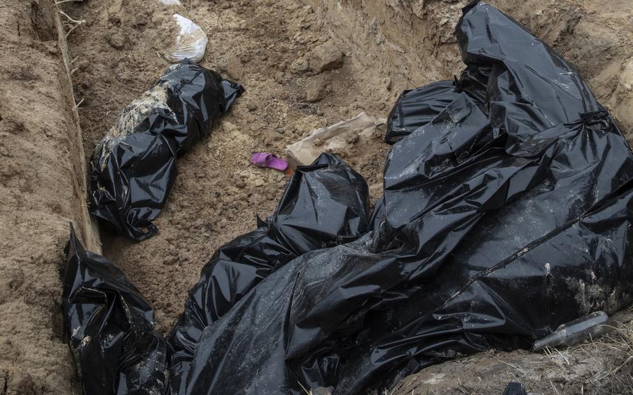 Bags contain bodies discovered in a mass grave outside the church. 