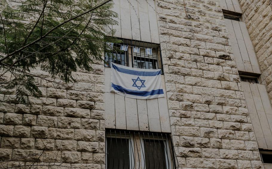 Israeli flags hang in the Gordons’ building in Jerusalem. “Being American is part of our identity,” Pesi Gordon said. “But he was very, very connected to Israel. He gave his life for it.” 
