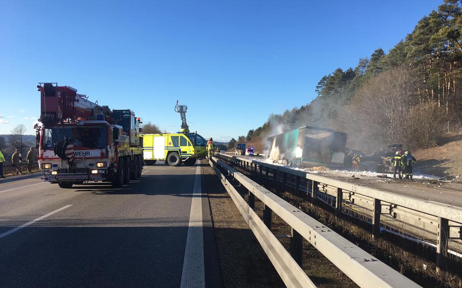 Firefighters work at the scene of a crash between a civilian semitrailer and parked U.S. military vehicles on Autobahn 3 near Parsberg, Germany, on Dec. 20, 2021. Two U.S. soldiers are under investigation for their involvement in events leading to the fatal crash.