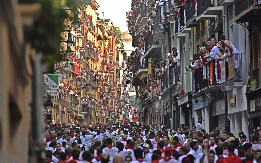 People run through the streets ahead of fighting bulls and steers during the first day of the running of the bulls at the San Fermin Festival in Pamplona, northern Spain, Thursday, July 7, 2022. 