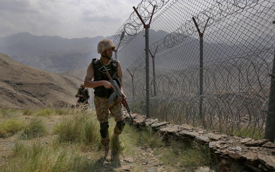  In this Aug. 3, 2021 file photo, Pakistan Army troops patrol along the fence on the Pakistan Afghanistan border at Big Ben hilltop post in Khyber district, Pakistan. 