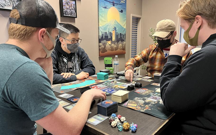 Service members wear masks while playing Magic the Gathering at the USO on Yokota Air Base, Japan, Jan. 14, 2022. 