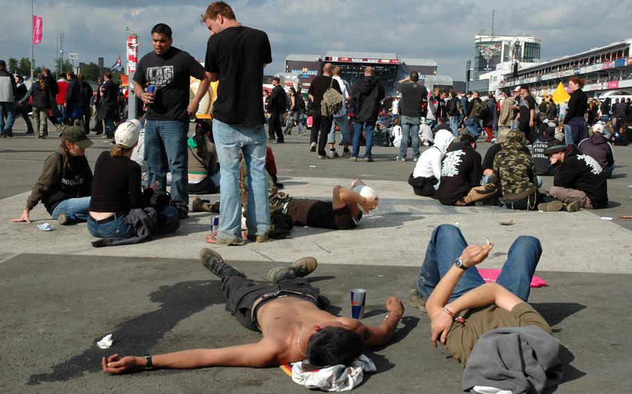 Two men lie on the ground as others stand near them.