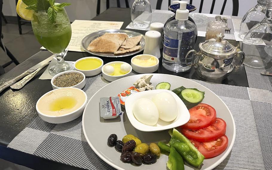 A dinner spread at a cafe in Rainbow Street in Amman, Jordan, included hummus, halvah, pita and date molasses. The cats that roam the street are also well-fed.