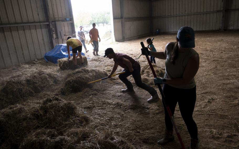 Volunteers help clear out a barn on May 20, 2023, during a clean up event for Trails of Purpose ahead of the opening of their new location in Virginia Beach. Trails of purpose provides equine therapy for members of the military and hopes to move nationwide to all major military areas.