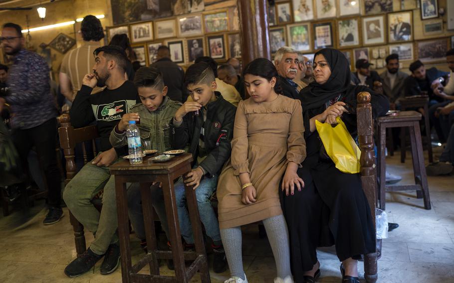 A family drinks tea at the Alshabander cafe on Al-Mutanabbi street in Baghdad, Iraq, Friday, Feb. 24, 2023. Iraq’s capital today is full of life and a sense of renewal, its residents enjoying a hopeful, peaceful interlude in a painful modern history.