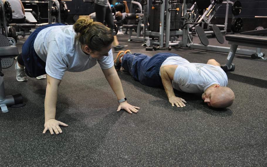 Senior Airman Christian Terrill, 445th Aeromedical Staging Squadron medical technician, demonstrates the proper techniques of doing a pushup for Senior Airman Billie Dunigan, also a 445th ASTS member, at Wright-Patterson Air Force Base, Ohio, in April 2017.