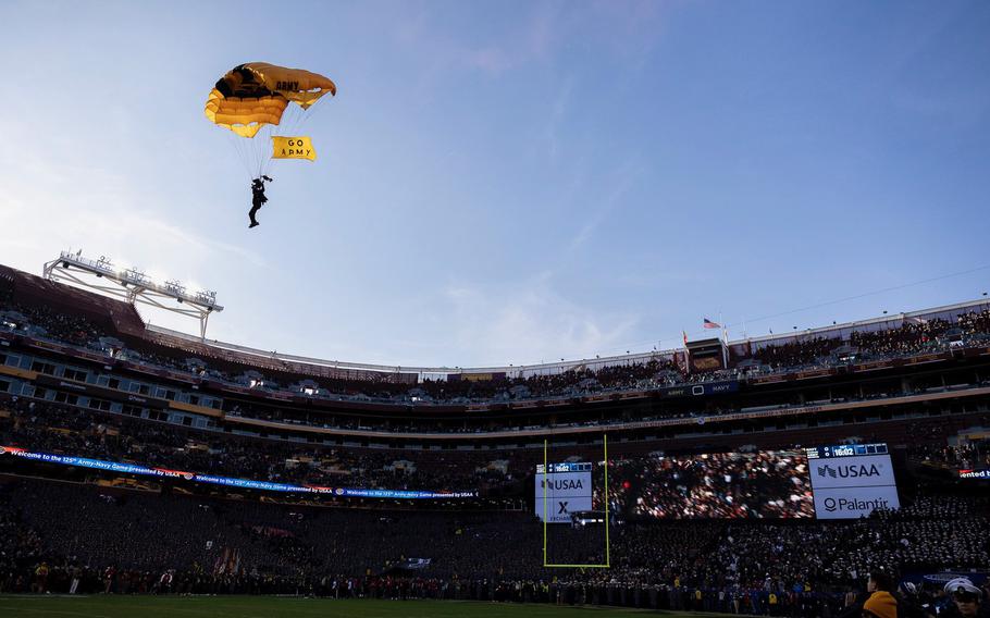 An Army parachutist prepares to land in the center of the field.