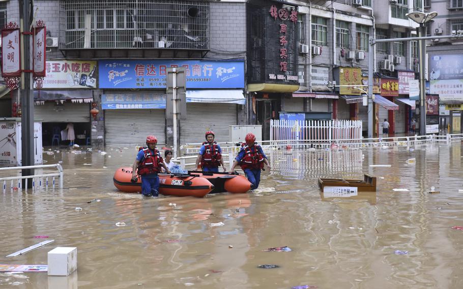 In this photo released by Xinhua News Agency, rescuers evacuate people stranded after flooding caused by heavy rain in the city of Jian'ou in southeast China's Fujian Province, June 19, 2022.