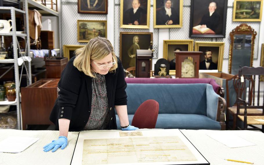 Amanda Lange, Curatorial Department Director and Curator of Historic Interiors at Historic Deerfield, looks over the recently restored Revolutionary War battle plan document by Major Moses Ashley of Westfield.