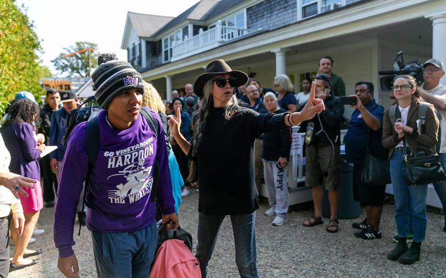 A Venezuelan migrant is led onto a bus at St. Andrews Episcopal Church on Friday, Sept. 16, 2022, in Edgartown, Mass on the island of Marthas Vineyard. A group of 48 migrants was flown to the island from Texas earlier this week, leaving them stranded. They are now being transferred to a military base in Cape Cod.