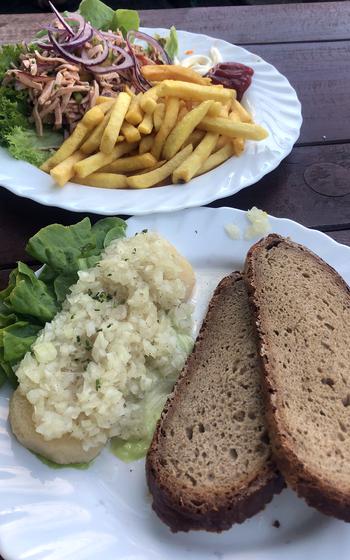 Handkaese with mussigg, foreground, and wurst salad with fries as served at the Biergarten in Darmstadt, Germany. Handkaese is a relatively low-fat sour milk cheese that gets its name from how it was originally formed, with the hands. Wurst salad is made with sliced cold cuts and pickles in a vinegar dressing and is topped with red onions. 