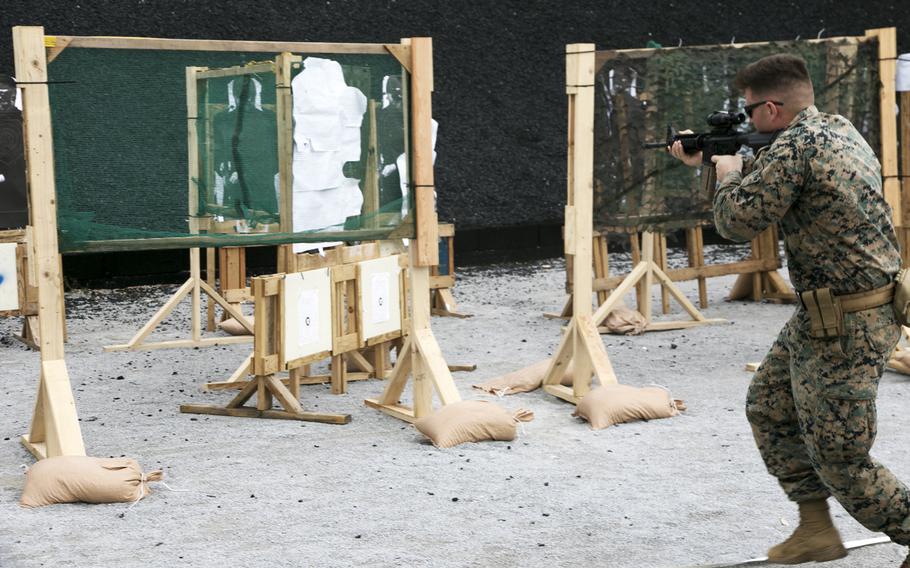 Marine Staff Sgt. Jonathan Birkeland hustles through an action rifle event during the Far East Marksmanship Competiton at Camp Hansen, Okinawa, Dec. 13, 2022.