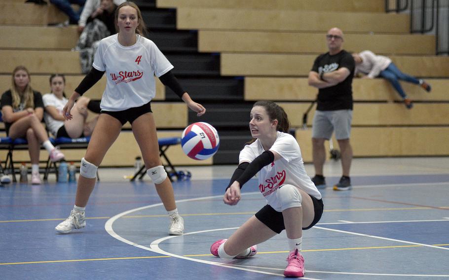 SHAPE's Jessica Moon of the White Team digs for a ball during a DODEA-Europe all-star volleyball match on Nov. 4, 2023, at Ramstein High School on Ramstein Air Base, Germany. Stuttgart's Berea Bryan, also of the WHite Team, watches in the background.